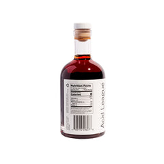 Pouring Acid League Strawberry Rosé Living Vinegar to brighten a salad.