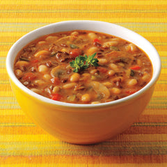Amy's Soup close-up of tomatoes, white beans, onions, zucchini and mushrooms.
