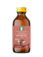 AYURVEDASHREE mustard oil poured from wooden churner, traditional extraction preserves nutrients.