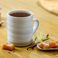 Steaming cup of Bigelow Vanilla Caramel Black Tea with creamy aroma.