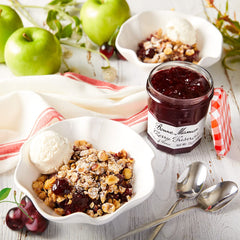 Close-up of glossy Bonne Maman Cherry Preserves in glass jar, highlighting fruit quality.