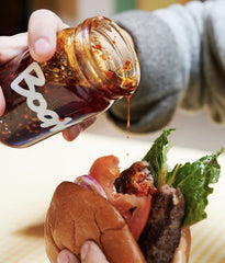 Boon Sauce Chili Oil bottle beside a sizzling skillet for ready-to-use heat.