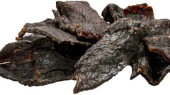 Buffalo Bills Hickory Beef Jerky piece ready to bite, ideal for travel and workouts.