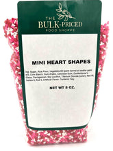 The Bulk-Priced Food Shoppe mini heart sprinkles decorate cupcakes with red, white, and pink.