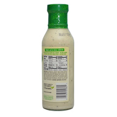 Cardini's Caesar dressing pour image highlighting easy drizzle on greens.