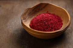 Cerez Pazari sumac spice powder close-up texture reveals fine, vibrant red-tan dust