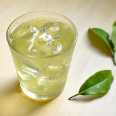 Hot brew shows vibrant green color with nutty Genmaicha notes in a cup.