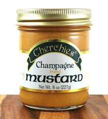 Pouring Cherchies Champagne Mustard to enrich a dish with bright tang.