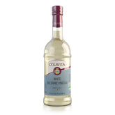 Colavita White Balsamic Vinegar bottle pouring over a crisp salad for a delicate finish.