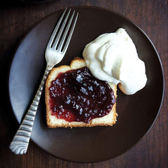 Open jar shows ruby jam, perfect for tasting and recipe ideas.