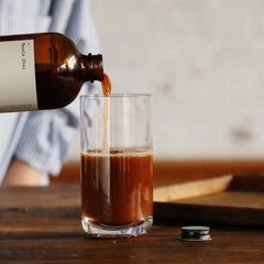 DONA bottle label detail emphasizes Brooklyn craft and small-batch quality.