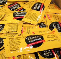 Close-up of Dukes sugar-free mayo packets highlighting convenient packaging for quick meals.