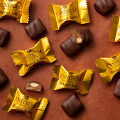 Milk chocolate coated almond toffee close-up highlighting texture.
