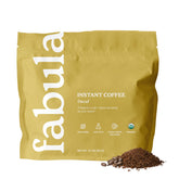 Fabula Organic Instant Decaf Coffee jar with steaming cup, showcasing low-acid, smooth flavor