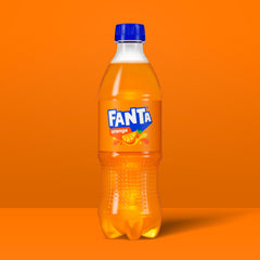 Fanta Orange Soda being poured into a tall glass showing vibrant bubbles.