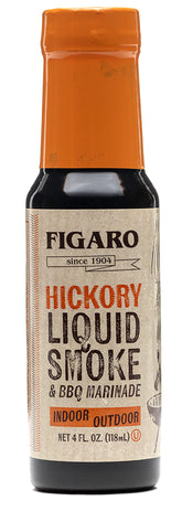 Figaro Hickory Liquid Smoke bottle being used to flavor steak indoors.