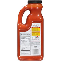 Pouring Frank's RedHot Buffalo Wings Sauce over wings for heat