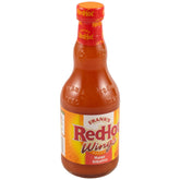 Frank's RedHot Mango Habanero bottle pouring to elevate wings with fruity heat.