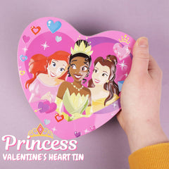 Galerie Disney Princess chocolates arranged in heart shape on tin surface.