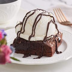 Ghirardelli Black Label bottle pouring over a dessert plate.