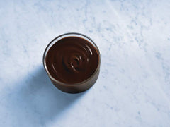 Ghirardelli chocolate sauce drizzle on a dessert plate for plating and topping