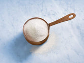 Ghirardelli Classic White Frappe Mix being poured to form a creamy beverage base.