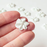 Global Sugar Art mini royal icing flowers in white with pearls for elegant wedding cupcakes.