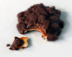Mouthwatering bite of GooGoo Clusters Original with creamy milk chocolate and chewy centers.