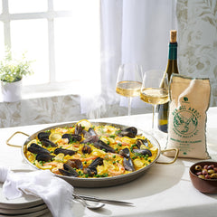 Gourmanity Paella rice in cooking pot shows creamy, absorbent results for dinner.