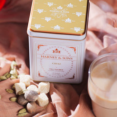 Gift-ready Harney & Sons chai tin on a cozy shelf, ideal for tea lovers.