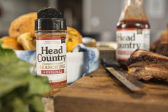 Head Country Championship Seasoning on ribs sizzling on the grill.