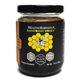 Health Harvest Tualang Honey jar close-up, raw and unfiltered, rich amber color.