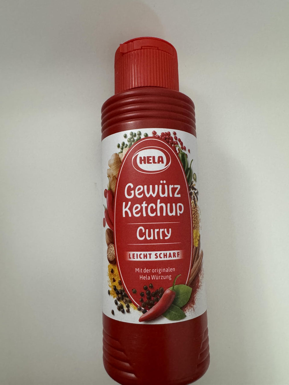 HELA Curry Gewurz Ketchup Scharf bottle pouring for burgers.