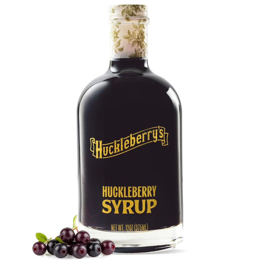 HUCKLEBERRY'S BREAKFAST · LUNCH huckleberry syrup bottle pouring on pancakes for a gourmet morning