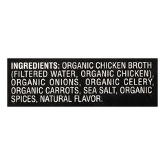 Imagine Organic Free Range Chicken Broth carton being held up to show fresh ingredients.