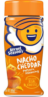 Kernel Season's Nacho Cheddar seasoning bottle pouring onto popcorn for bold flavor.