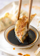 Kikkoman Gyoza Dipping Sauce with dumplings and egg rolls for savory pairing