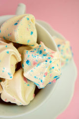 Krunchy Melts cotton candy flavor cookie beside fruit showcases playful snack moment.