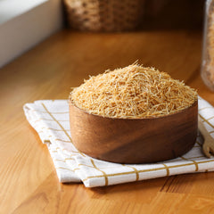 Kunafa assembly with kataifi sheets forming a crunchy top layer.