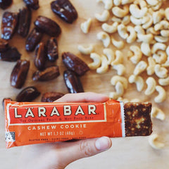 LÄRABAR Cashew Cookie bar being unwrapped, convenient for travel.