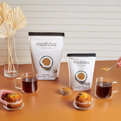 MADHAVA Coconut Sugar pouring into a coffee cup for smooth, natural sweetness.