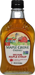 Pouring Maple Grove Farms syrup over waffles with smooth texture.