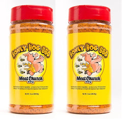 Meat Church Honey Hog rub bottles pouring to season pork and vegetables with sweet heat.
