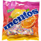 Mentos Fruit 150 single-serve pillow packs on an office desk for quick refreshment.