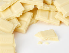 Milka Alpine milk white chocolate close-up, silky melt highlighted.