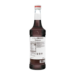 A glass with Monin Blackcurrant Syrup creating a rich, fruity drink.