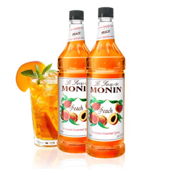 Monin Peach Syrup bottle on a kitchen counter highlighting authentic peach flavor for beverages.