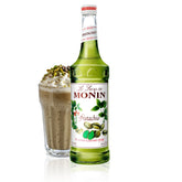 Monin Pistachio Syrup bottle being poured to showcase rich pistachio flavor for beverages
