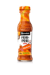 Nando's Medium Peri-Peri sauce bottle pour elevates grilled chicken and veggies.