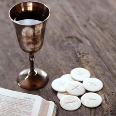 Needzo altar bread on liturgical table setup for Eucharist.